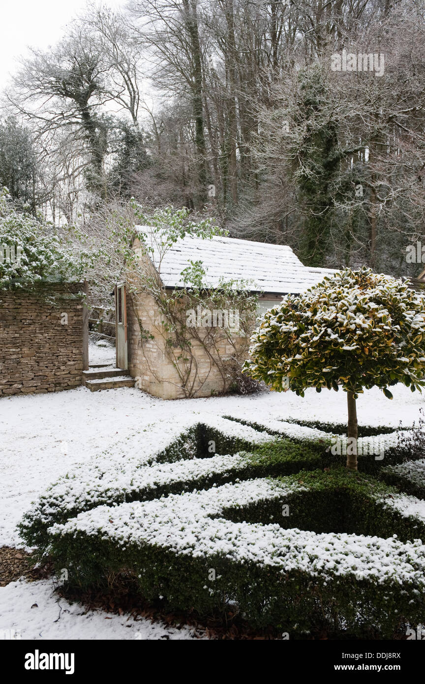 Blick auf schneebedeckte Gartenhaus gesehen über ein Feld umrandeten Kraut-Knoten Stockfoto