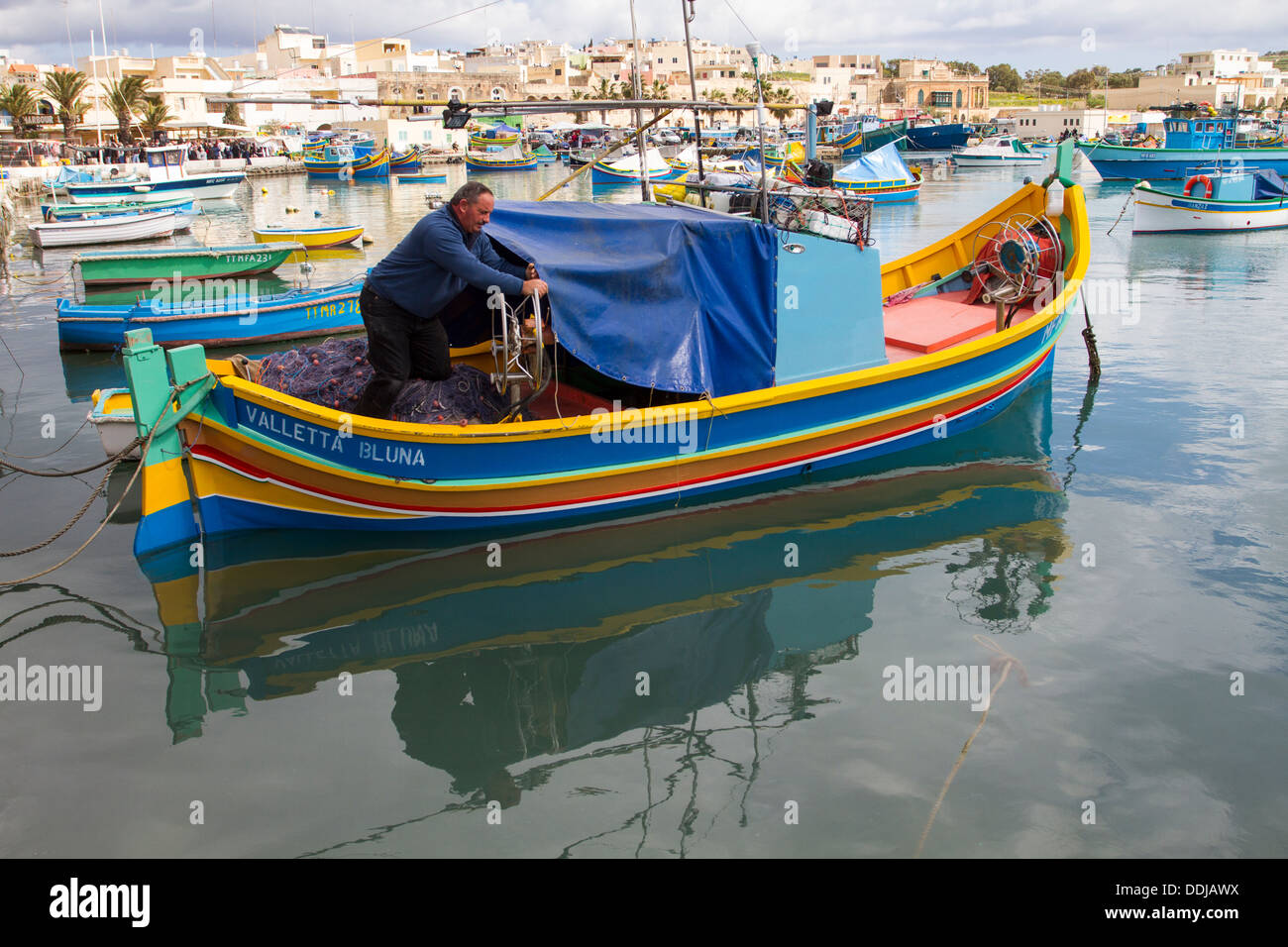 Fischer auf eine Luzzu, Marsaxlokk Hafen, Malta. Stockfoto