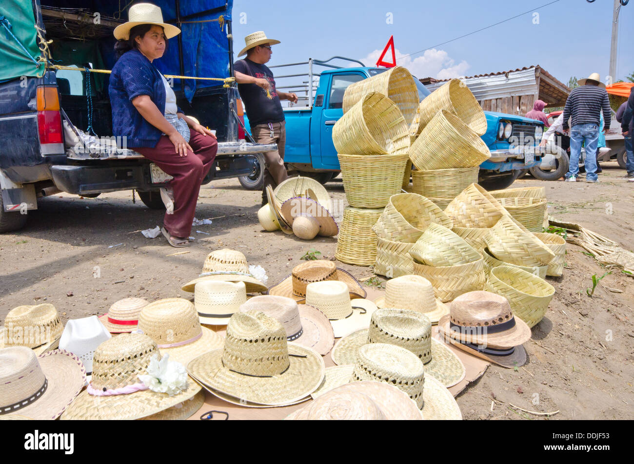 Frau verkaufen große Menge Körbe und Hüte (Sombreros) von der Rückseite eines LKW am Markttag in Mexiko Stockfoto