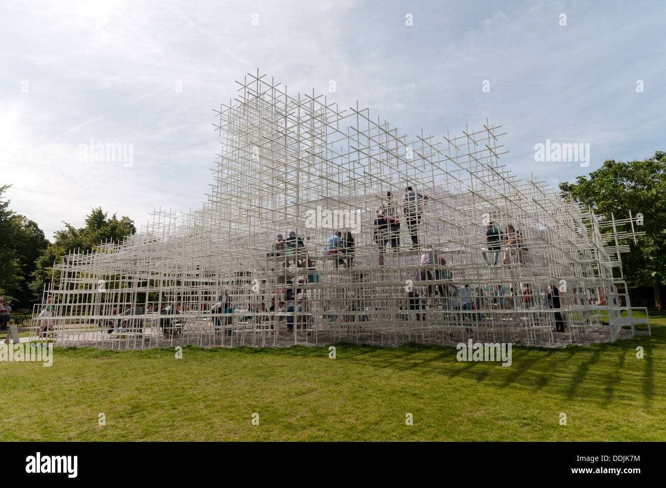 Besucher sitzen in 2013 Serpentine Gallery Summer Pavilion entworfen von dem japanischen Architekten Sou Fujimoto. Stockfoto