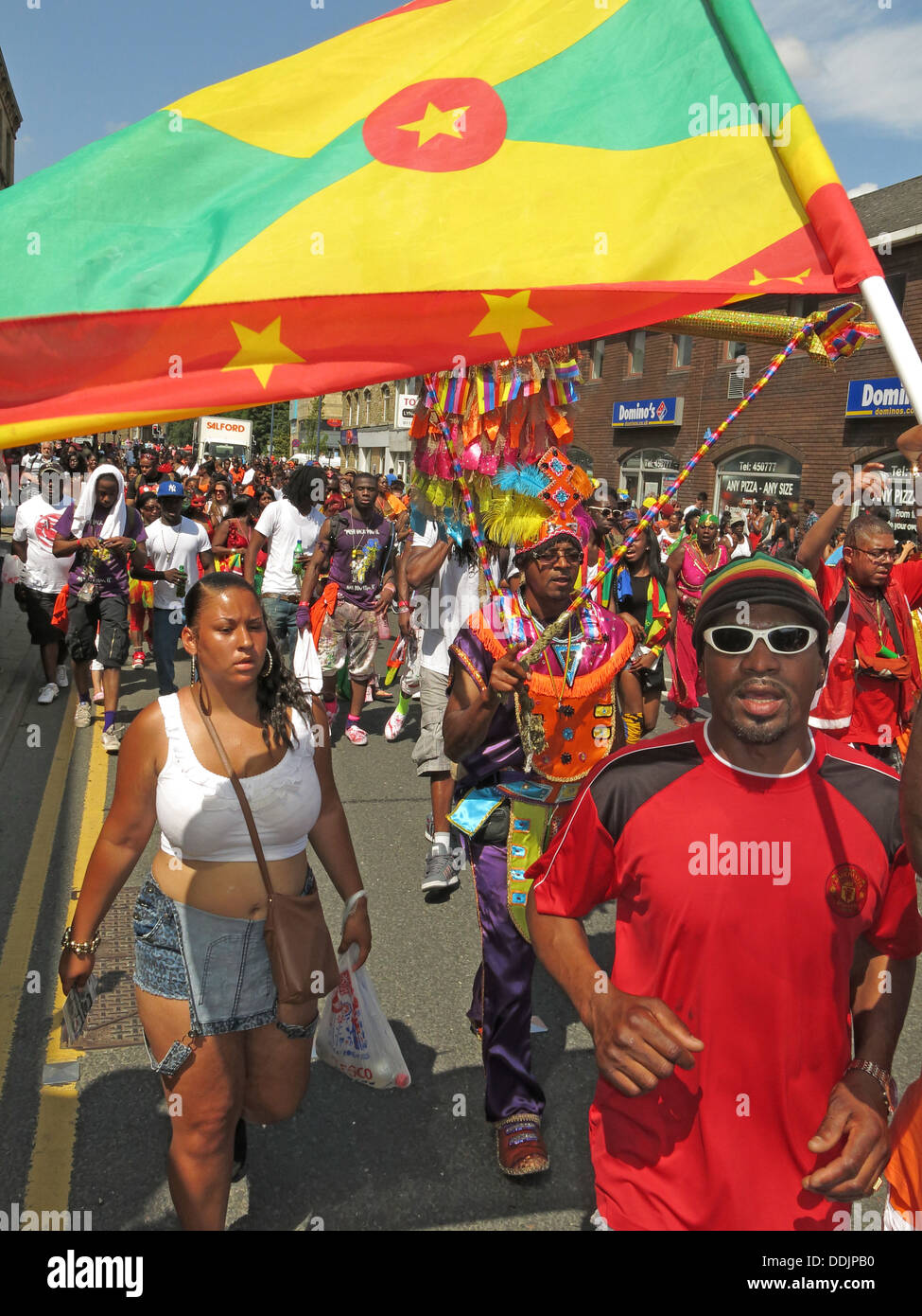 Kostümierte Tänzer mit Fahne aus Huddersfield Karneval 2013 Afrika Karibik Parade Straßenfest Stockfoto