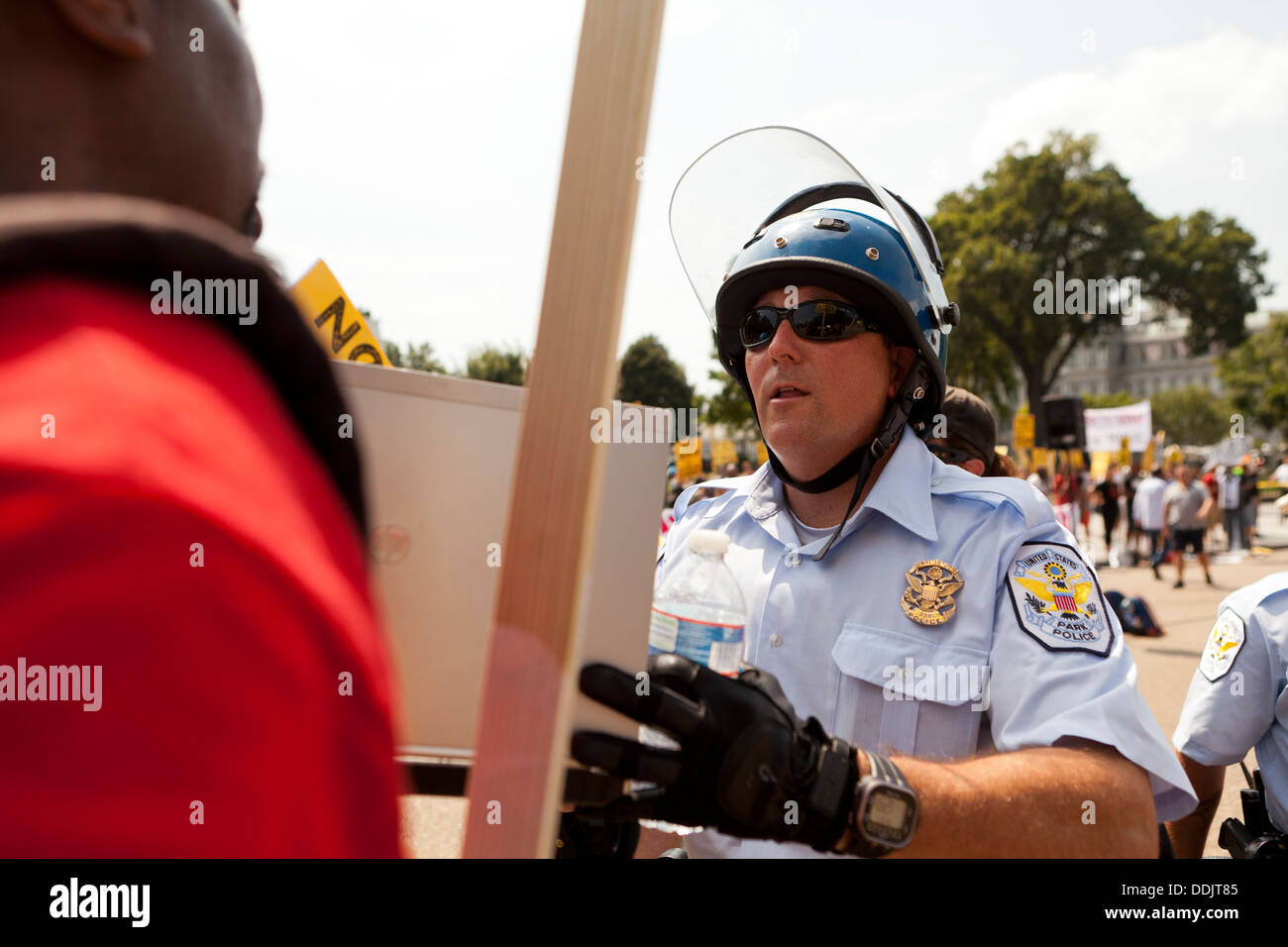 Polizist mit Demonstranten bei einer Kundgebung Stockfoto