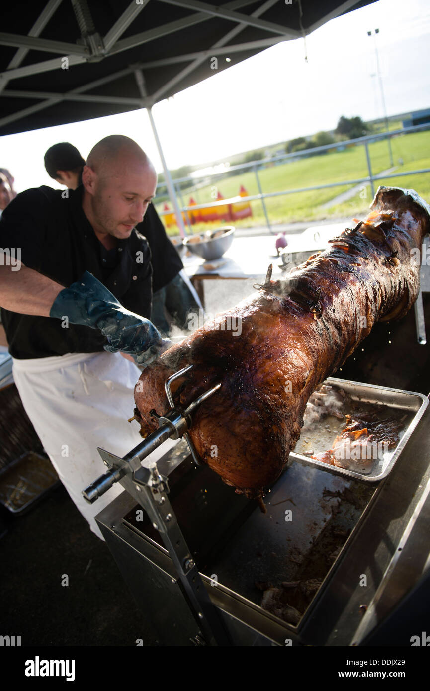 Ein Mann schnitzen eine volle gebratenes Schwein-Metzgete auf einer Party, UK Stockfoto