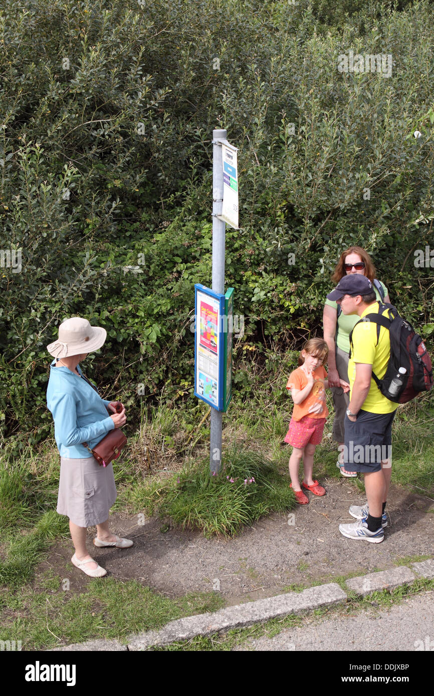 Passagiere warten an einer Bushaltestelle an einer Bushaltestelle in einem Bus-Warteschlange in ländlicher Umgebung in Cornwall Stockfoto