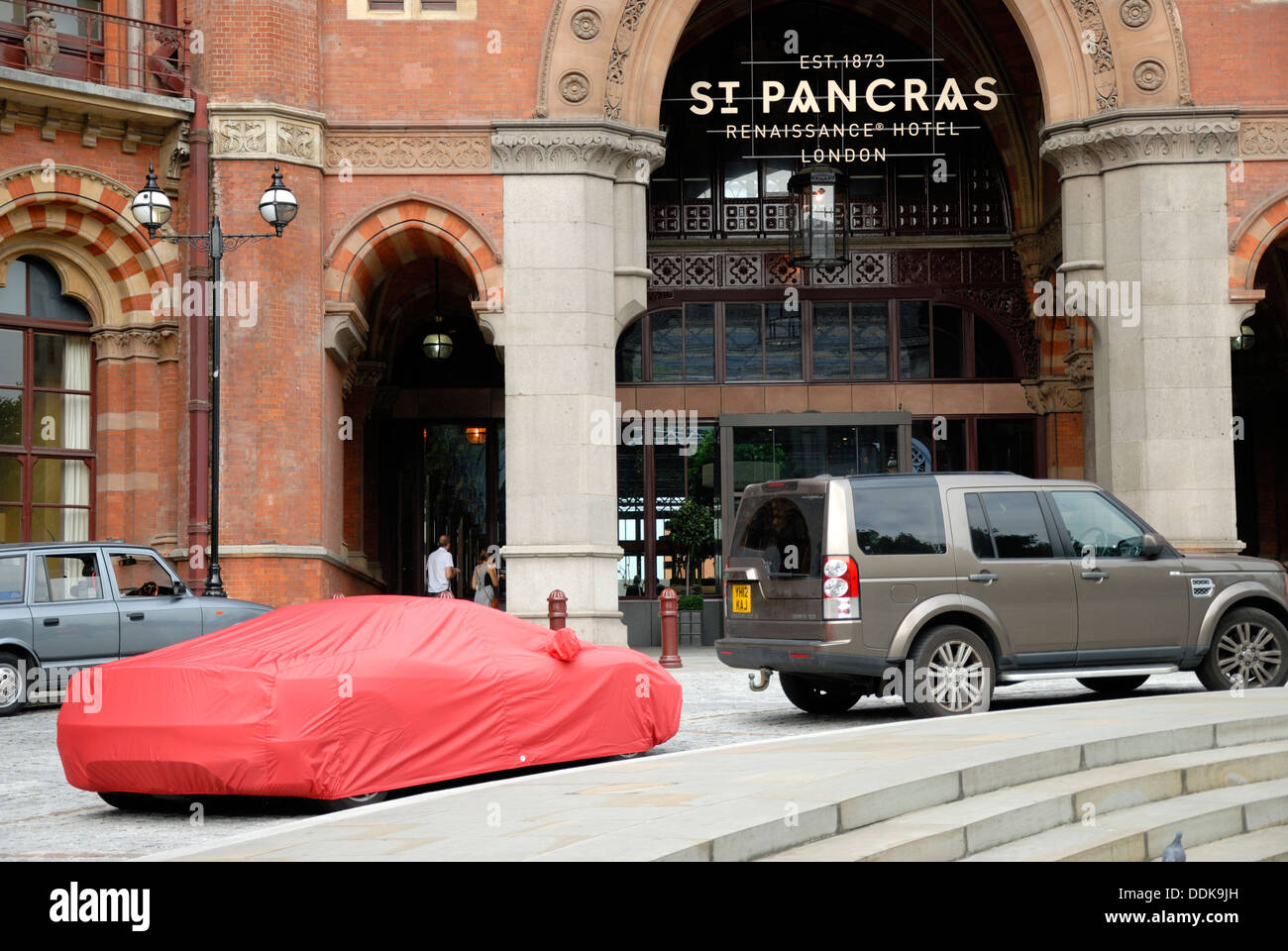 London, England, Vereinigtes Königreich. Auto unter rotem Einband außen St Pancras Station Stockfoto