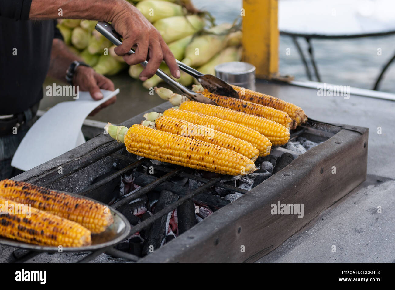 Person Maiskolben Grillen Stockfoto