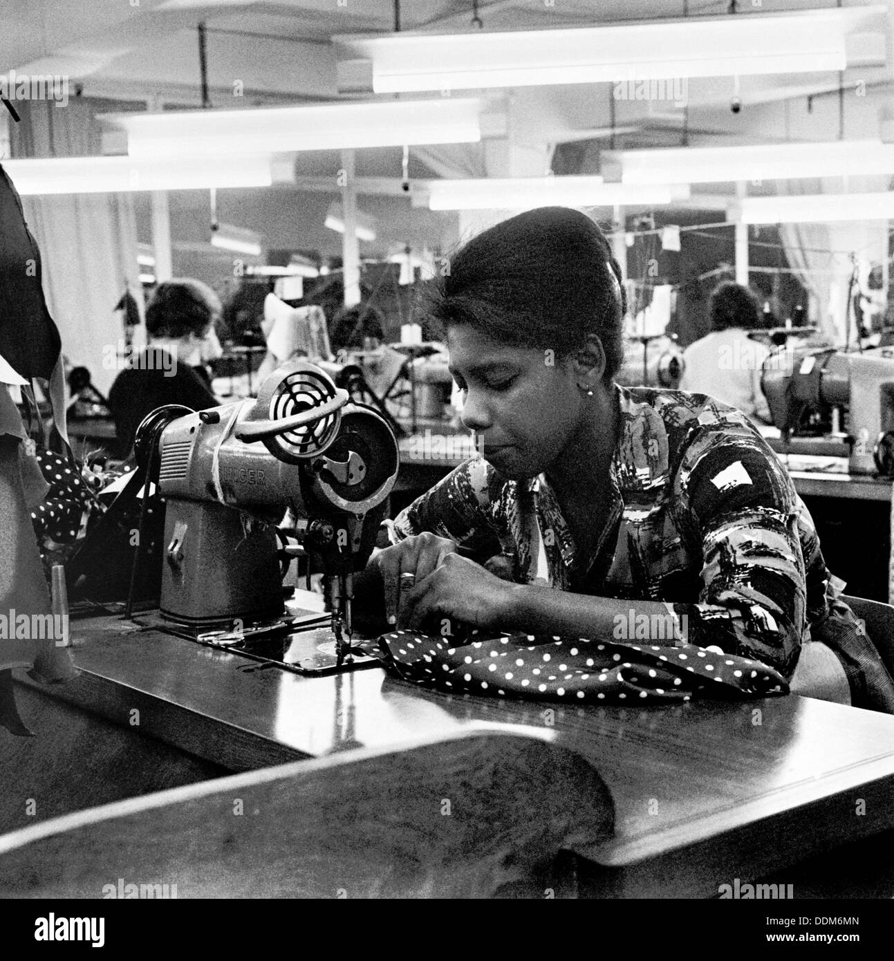 Frau arbeitet an einer Nähmaschine, London, (c1955-c1975?). Künstler: Henry Grant Stockfoto