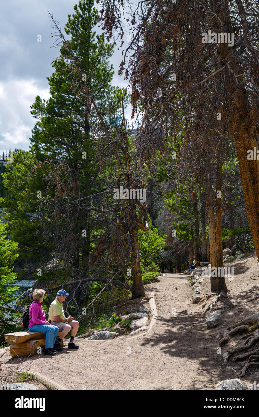 Mittleren gealterten paar sitzt durch die Bear Lake Trail im Sommer, Rocky Mountain Nationalpark, Colorado, USA Stockfoto