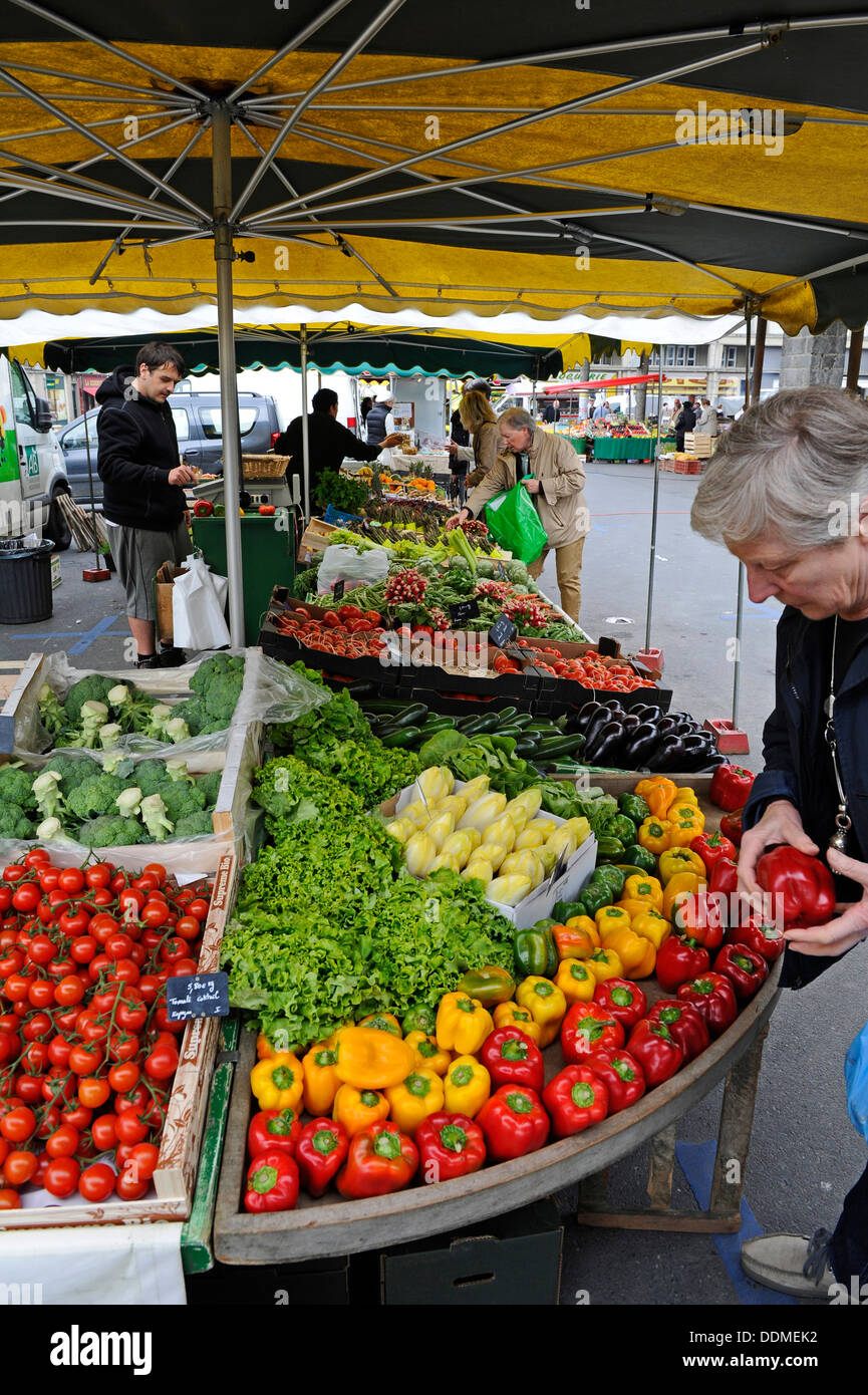 Rote und gelbe Paprika und anderes Gemüse zum Verkauf an einen offenen Markt in Coutances, Normandie, Frankreich. Stockfoto