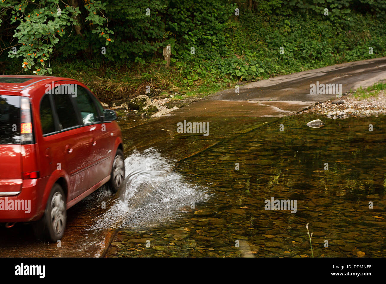 Familienauto fording einen Fluss bei Ford eine altmodische Art und Weise der Kreuzung Wasser ohne eine Brücke zu bauen Stockfoto