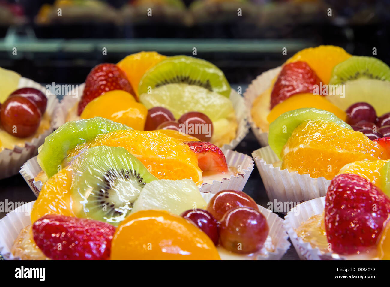 Lemon Curd Torten mit Obst Erdbeer Trauben Orange Melone Honigtau Pfirsich, Kiwi und Ananas an Bäckerei Shop Closeup Stockfoto