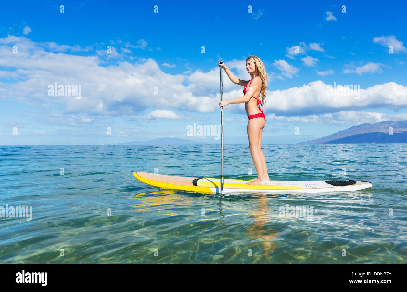 Attraktive Frau auf Stand Up Paddle Board, SUP, Tropical Blue Ocean, Hawaii Stockfoto