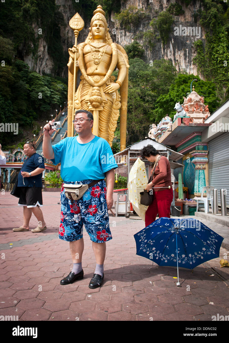 Nen Mann nimmt Fotos vor der Statue der Hindu Gottheit Murugan Stockfoto