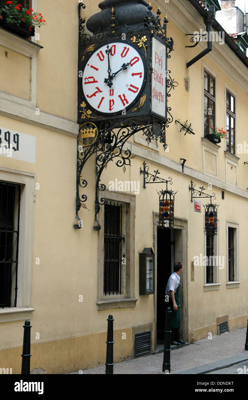 Eine große Uhr im Retro-Design an der Wand am Eingang der Brauerei und des Restaurants U Fleku, die aus dem Jahr 1499 im Stadtteil Nove Mesto in Prag, Tschechien, stammt Stockfoto