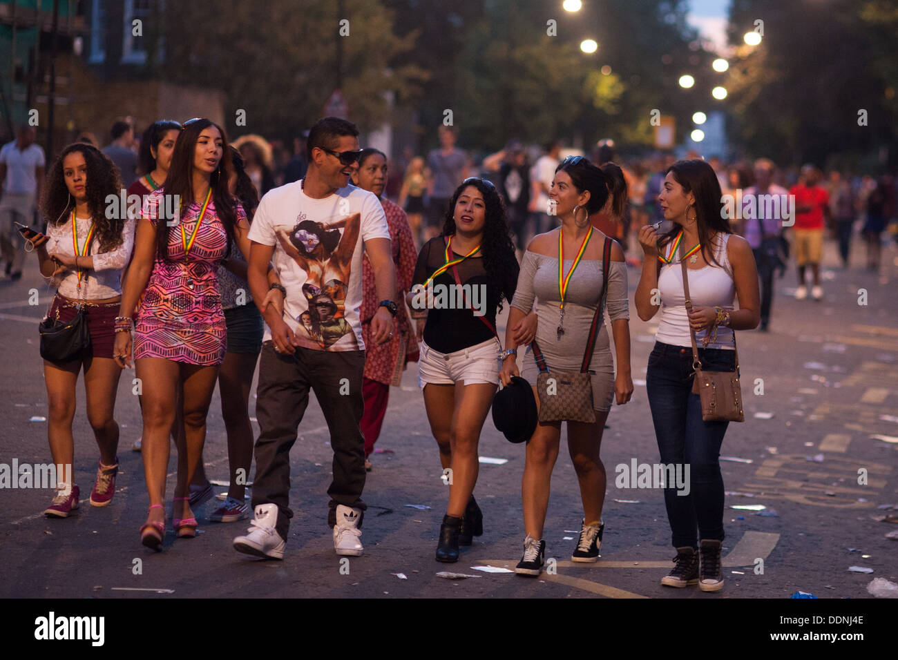 Glücklich Partygänger unterwegs zu Hause in den sterbenden Licht an einem Sommerabend in Notting Hill nach dem Karneval. Stockfoto