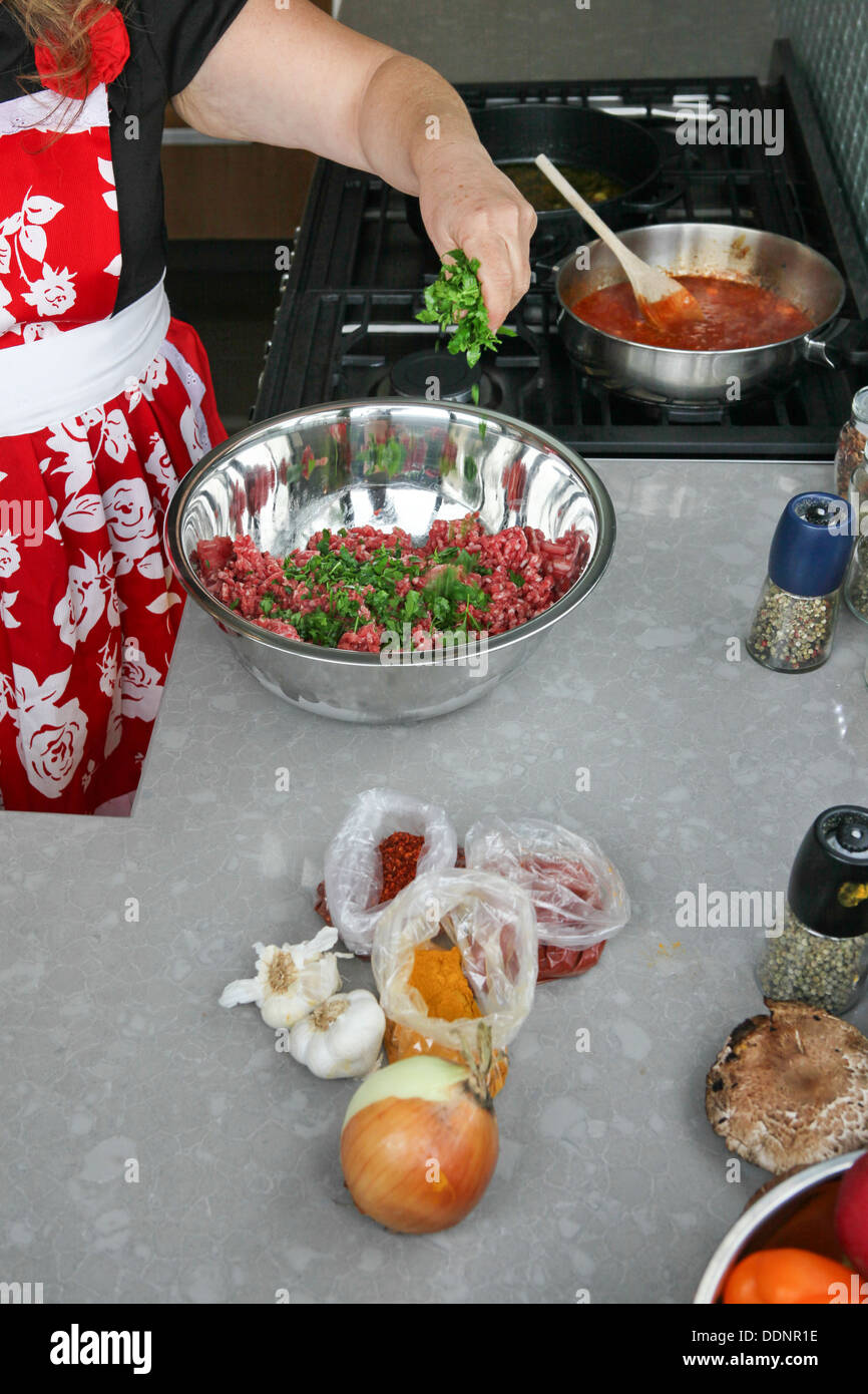 Marokkanische Fleischbällchen in Tomatensauce, die Zugabe von Kräutern, das Hackfleisch Kochen Stockfoto