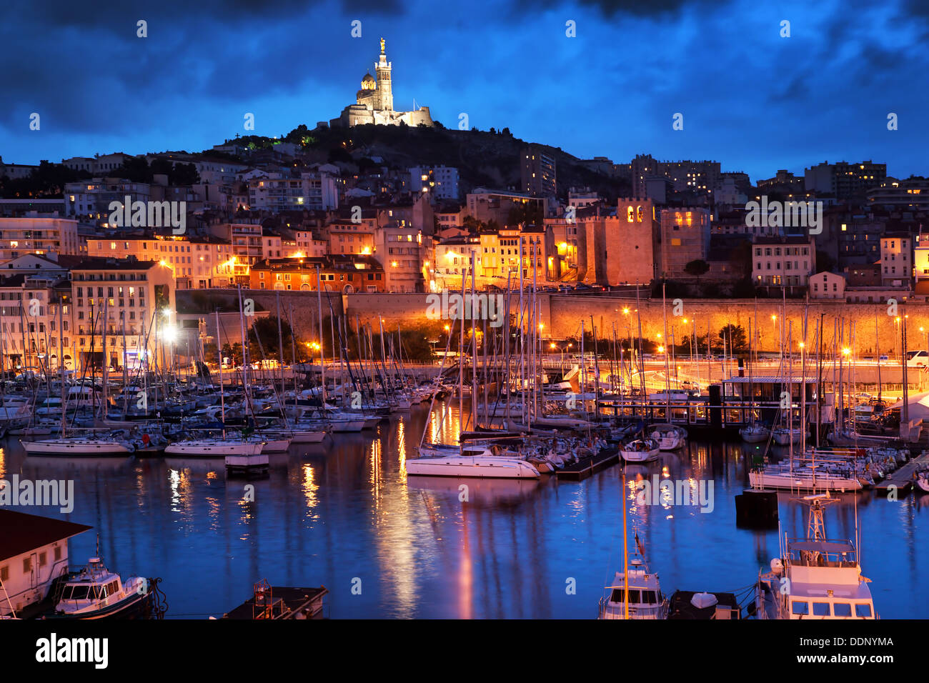 Hafen von Marseille, alten Hafen / Vieux Port, Frankreich in der Nacht mit Blick auf Notre Dame De La Garde auf dem Hügel in der Nacht Stockfoto