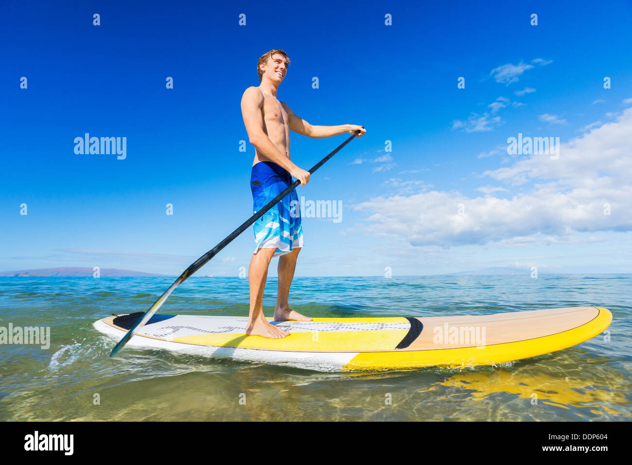 Attraktiver Mann auf Stand Up Paddle Board, SUP, Tropical Blue Ocean, Hawaii Stockfoto