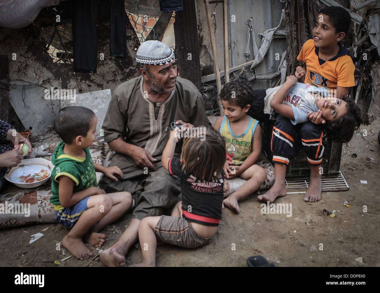 4. September 2013 - Gaza-Stadt, Gazastreifen, Palästinensische Autonomiegebiete - Salah al-Wadiya, deaktiviert ein palästinensischer Mann, spielt mit seinen Kindern in seinem Haus in al-Zaytoon Nachbarschaft in Gaza-Stadt am Sep 04, 2013. Al-Wadiya haben zehn Kinder, fünf von ihnen kann nicht zur Schule gehen, weil sie sind in extremer Armut leben, nachdem er seinen rechten Fuß bei einem Autounfall verloren (Credit-Bild: © Ezz Zanoon/APA Images/ZUMAPRESS.com) Stockfoto