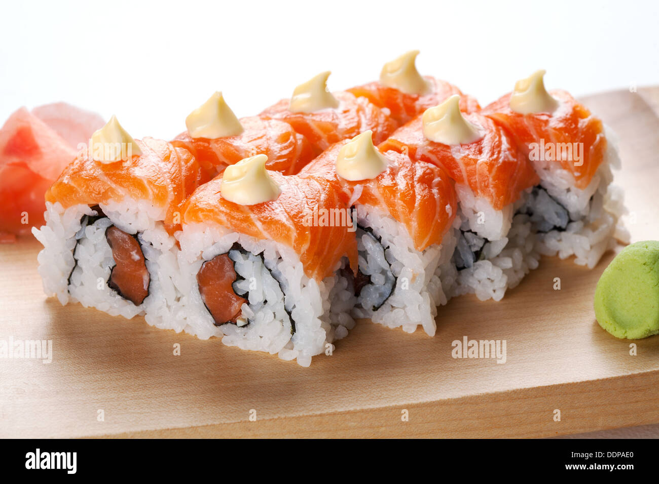 Lachs Sushi-Rollen auf Holzplatte. Stockfoto