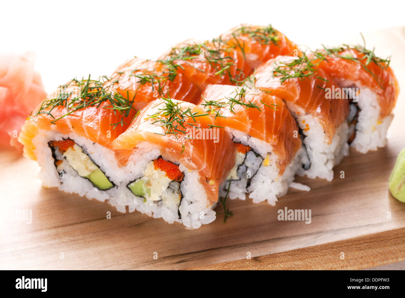 Lachs Sushi-Rollen auf Holzplatte. Stockfoto