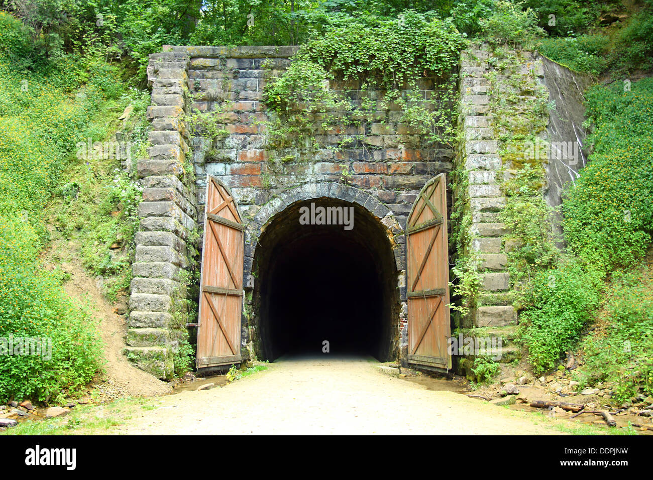 Ein altes steinernes tunnel Eingang auf einem Radweg in den Wäldern, die aus einer alten Eisenbahnlinie umgewandelt wurde. Stockfoto