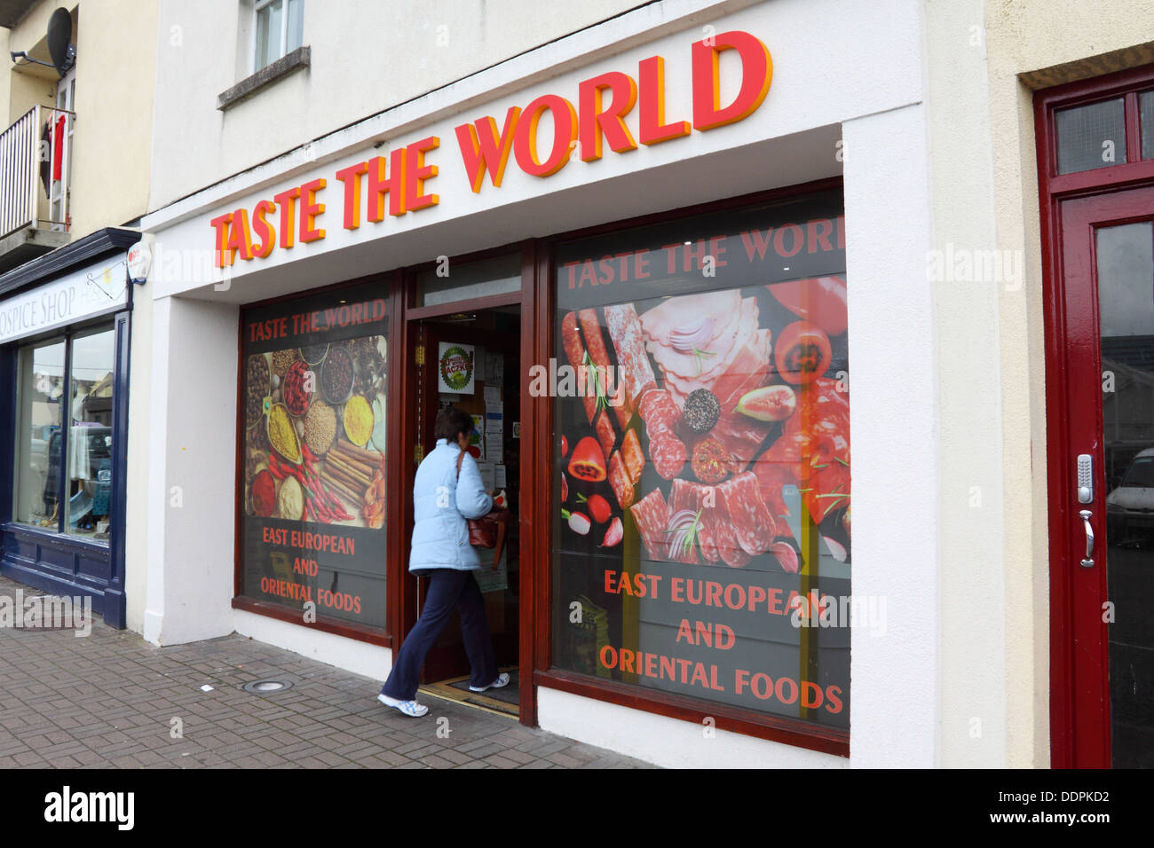 Frau-Shopper, die Eingabe "Geschmack die Welt" internationalen Lebensmittelgeschäft in Ballina, Irland Stockfoto