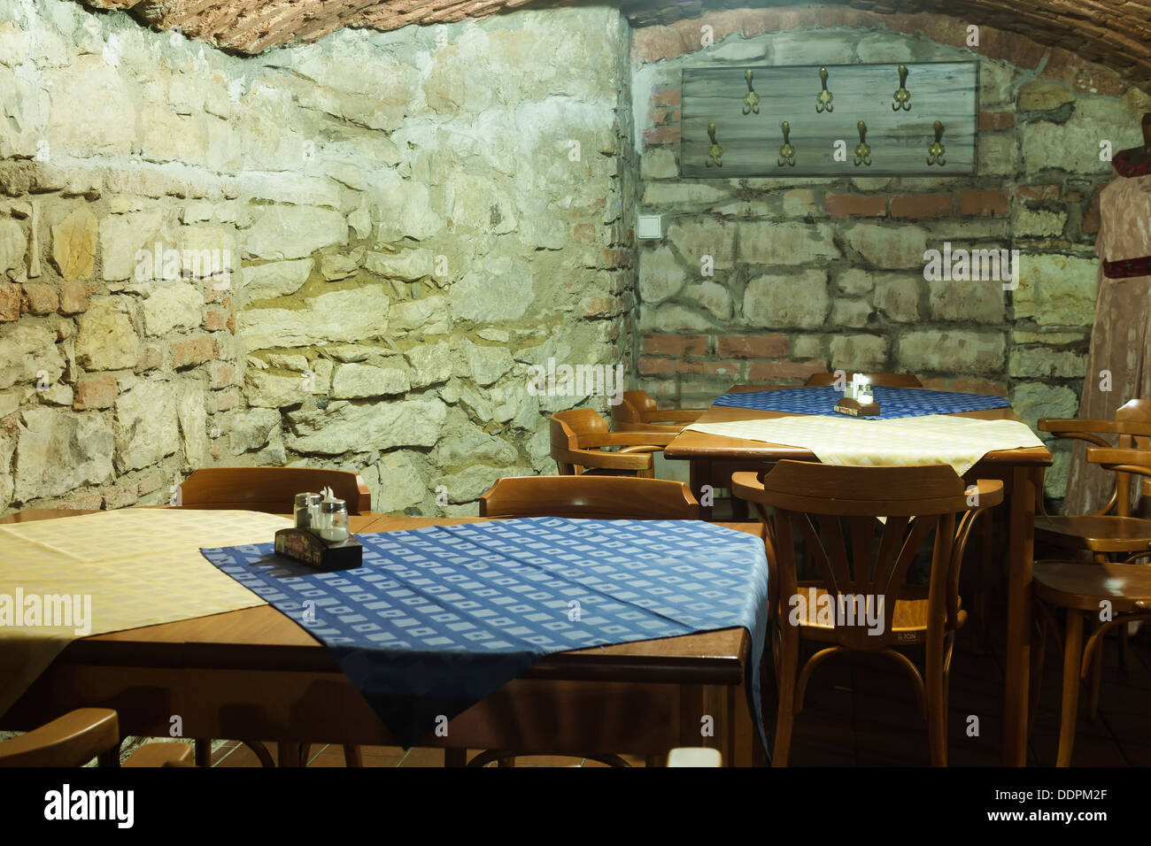 Tische und Stühle auf dem Hintergrund einer Steinmauer Stockfoto