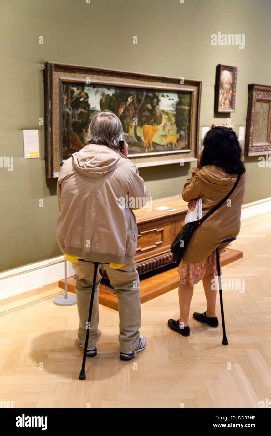 Ein paar sitzt auf Shooting Sticks schätzen Kunst Gemälde, The Ashmolean Museum, Oxford UK Stockfoto