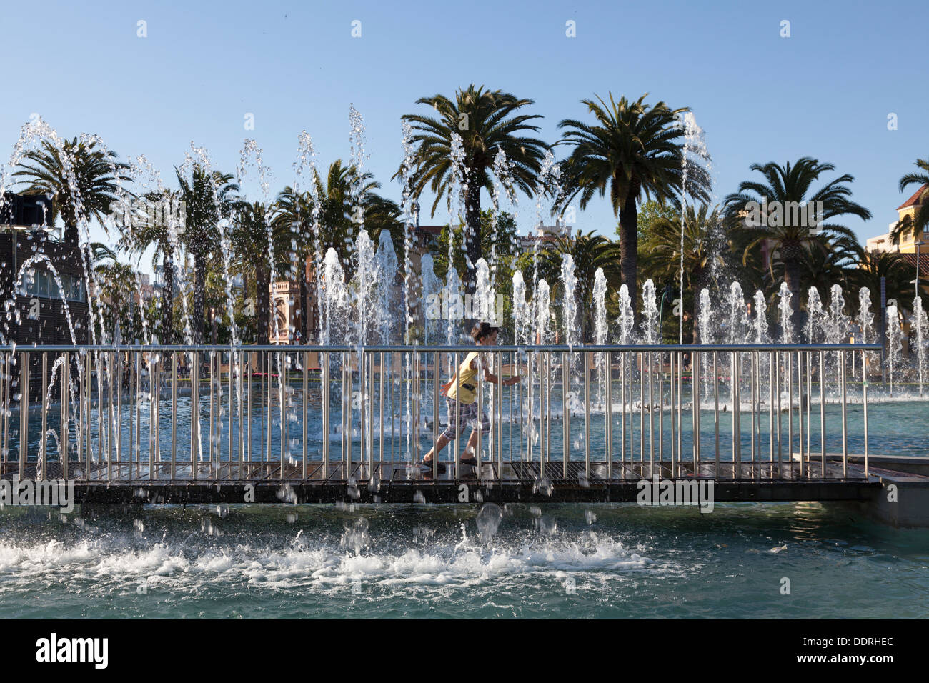 Kind läuft durch Brunnen an der Palmen-Promenade-Salou Stockfoto