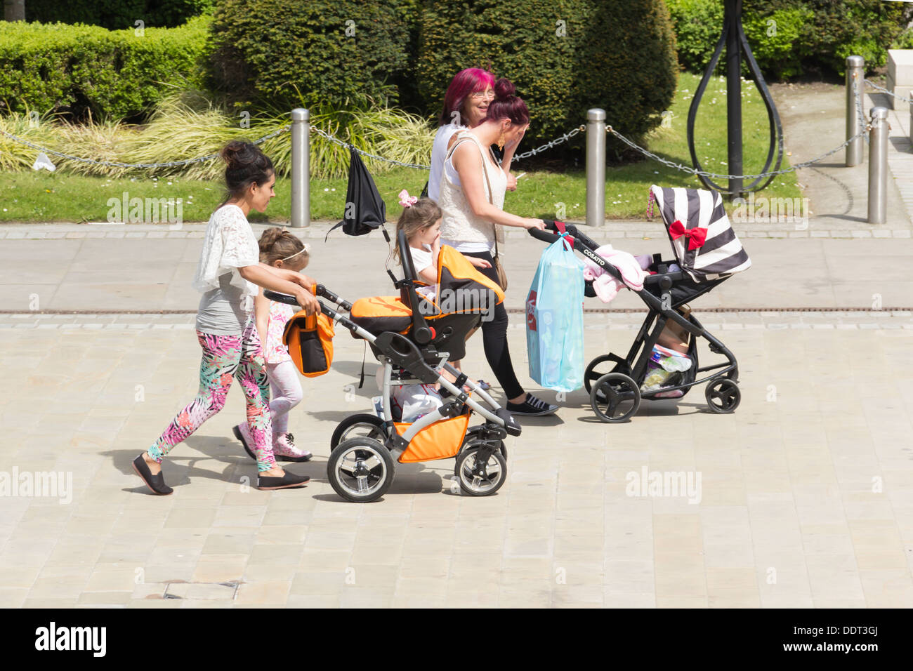 Mütter mit Kleinkindern und Kinderwagen Einkaufen in Victoria Square, Bolton, Lancashire. Stockfoto