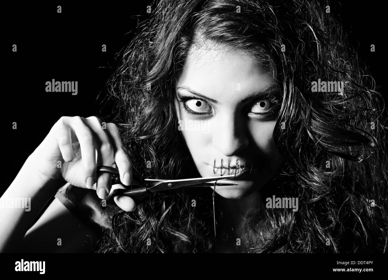 Horror erschossen: beängstigendes seltsames Mädchen mit Mund genäht schließen Sie den Faden abschneiden. Monochrom Stockfoto