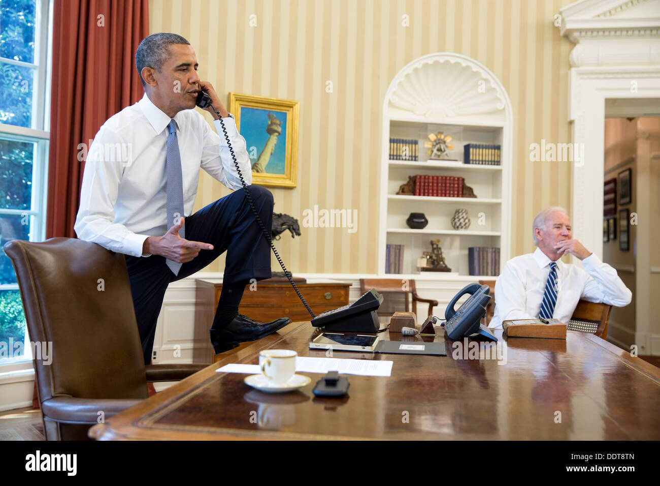 Präsident Barack Obama spricht am Telefon mit Lautsprecher des Hauses John Boehner, im Oval Office, Samstag, 31. August 2013. Vize-Präsident Joe Biden hört auf der rechten Seite. Stockfoto