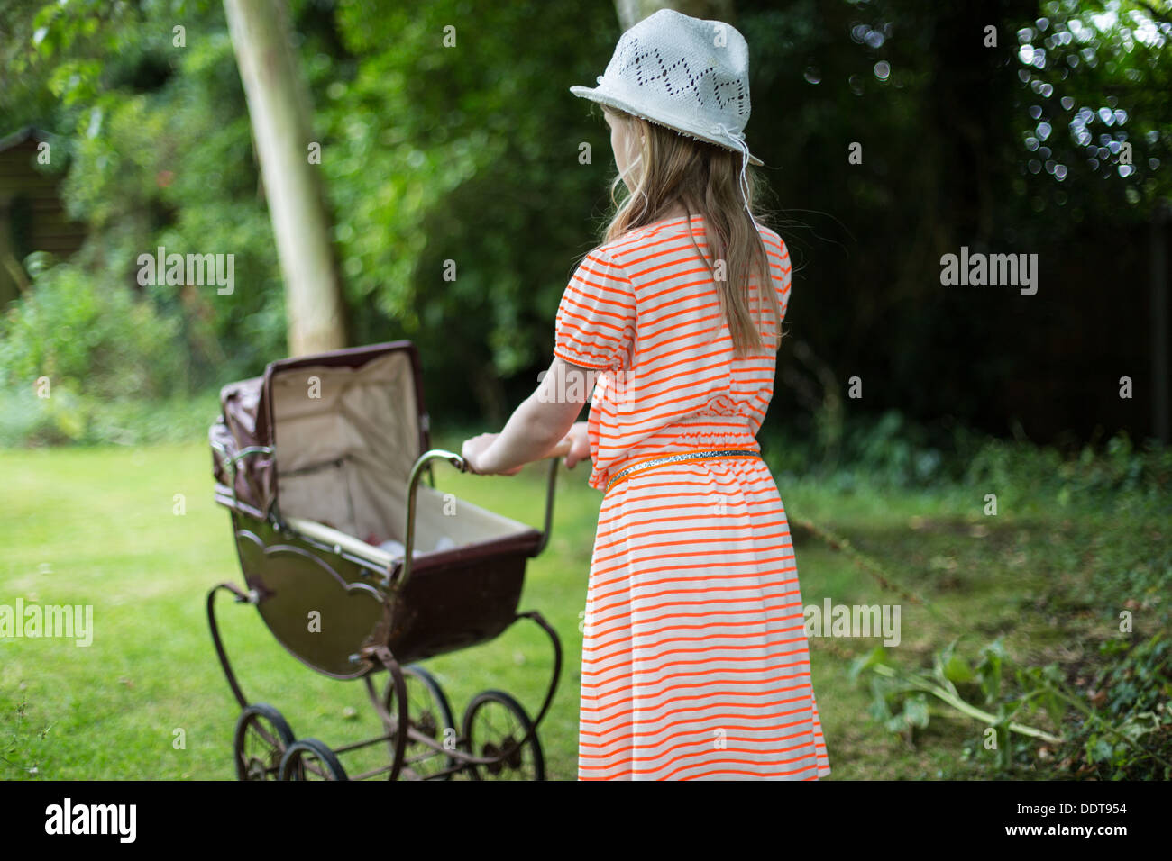 Junges Mädchen Puppen Kinderwagen schieben Stockfoto