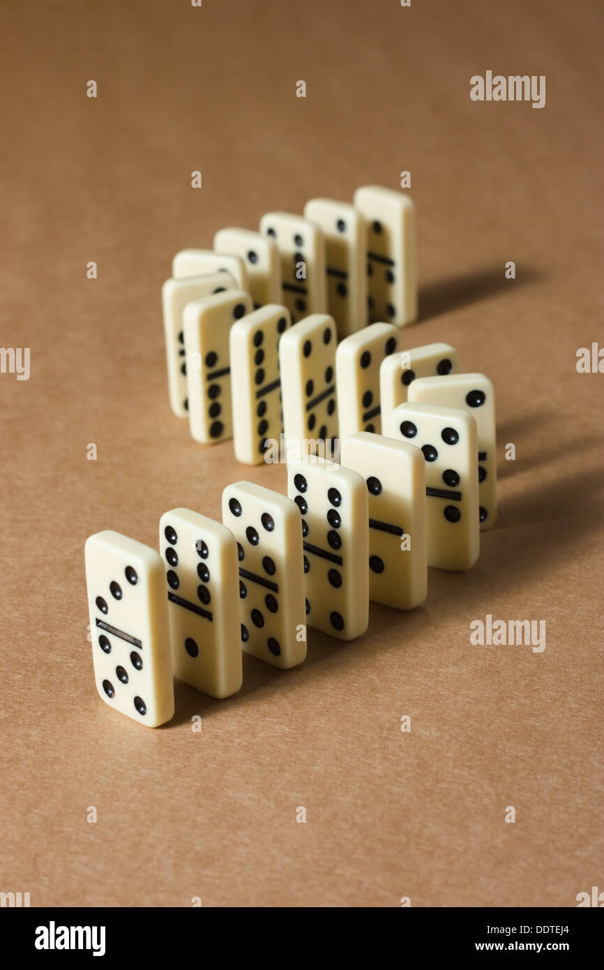 Weiße Dominosteine auf braunem strukturiertem Hintergrund Stockfoto
