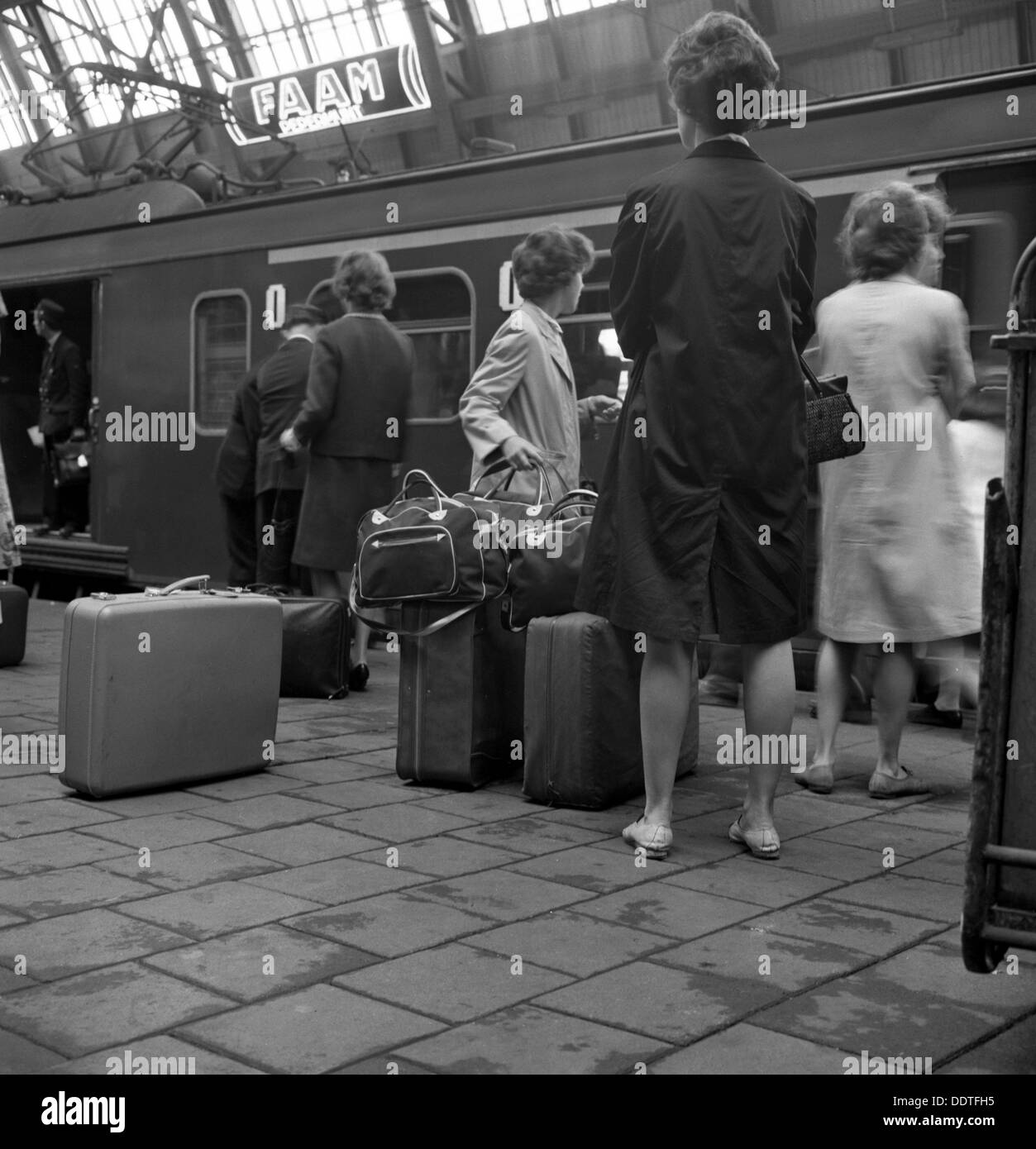 Passagiere auf einer Plattform an der Centraal Station, Amsterdam, Niederlande, 1963. Künstler: Michael Walters Stockfoto
