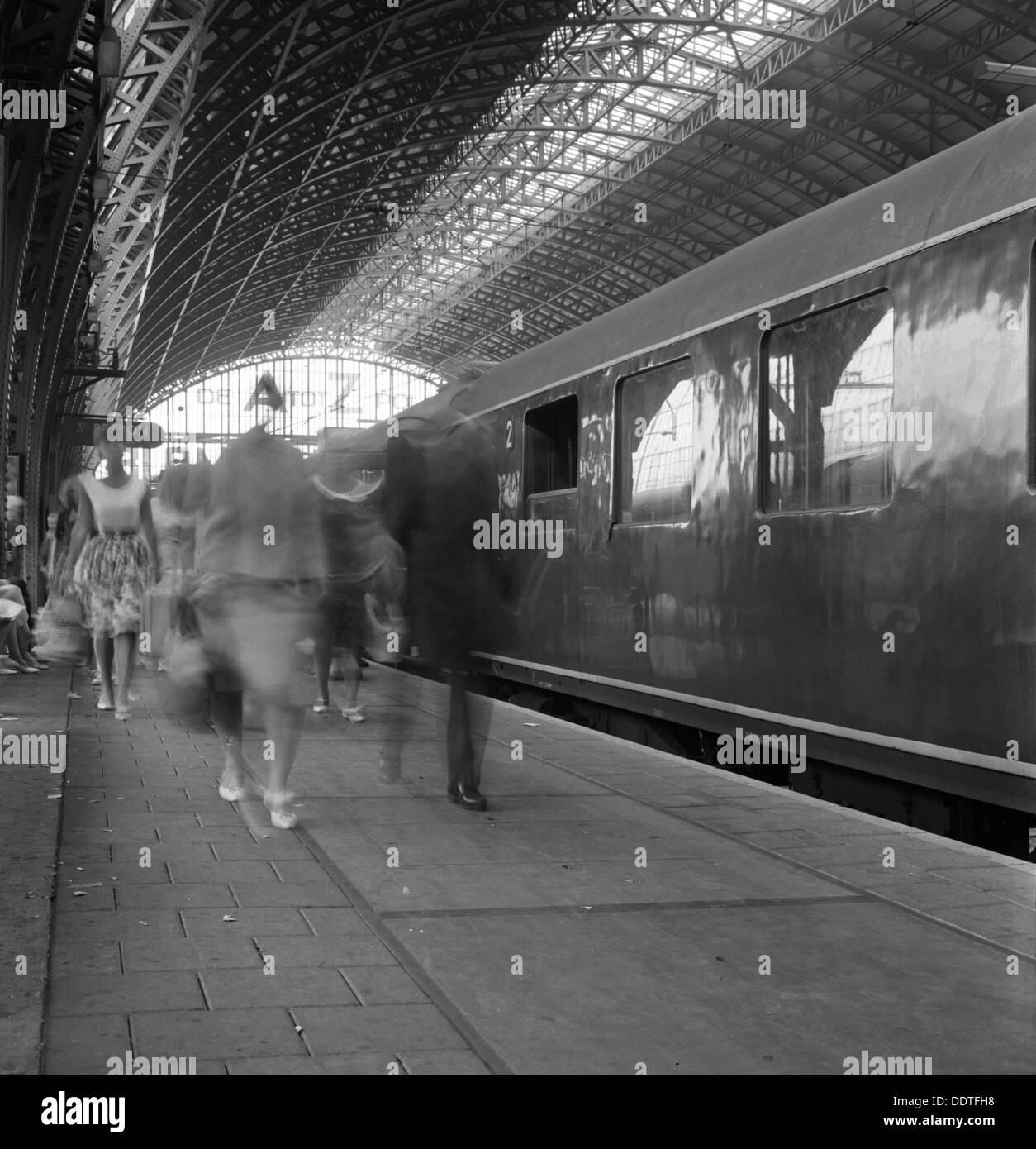 Reisende zu Fuß entlang einer Plattform an der Centraal Station, Amsterdam, Niederlande, 1963. Künstler: Michael Walters Stockfoto