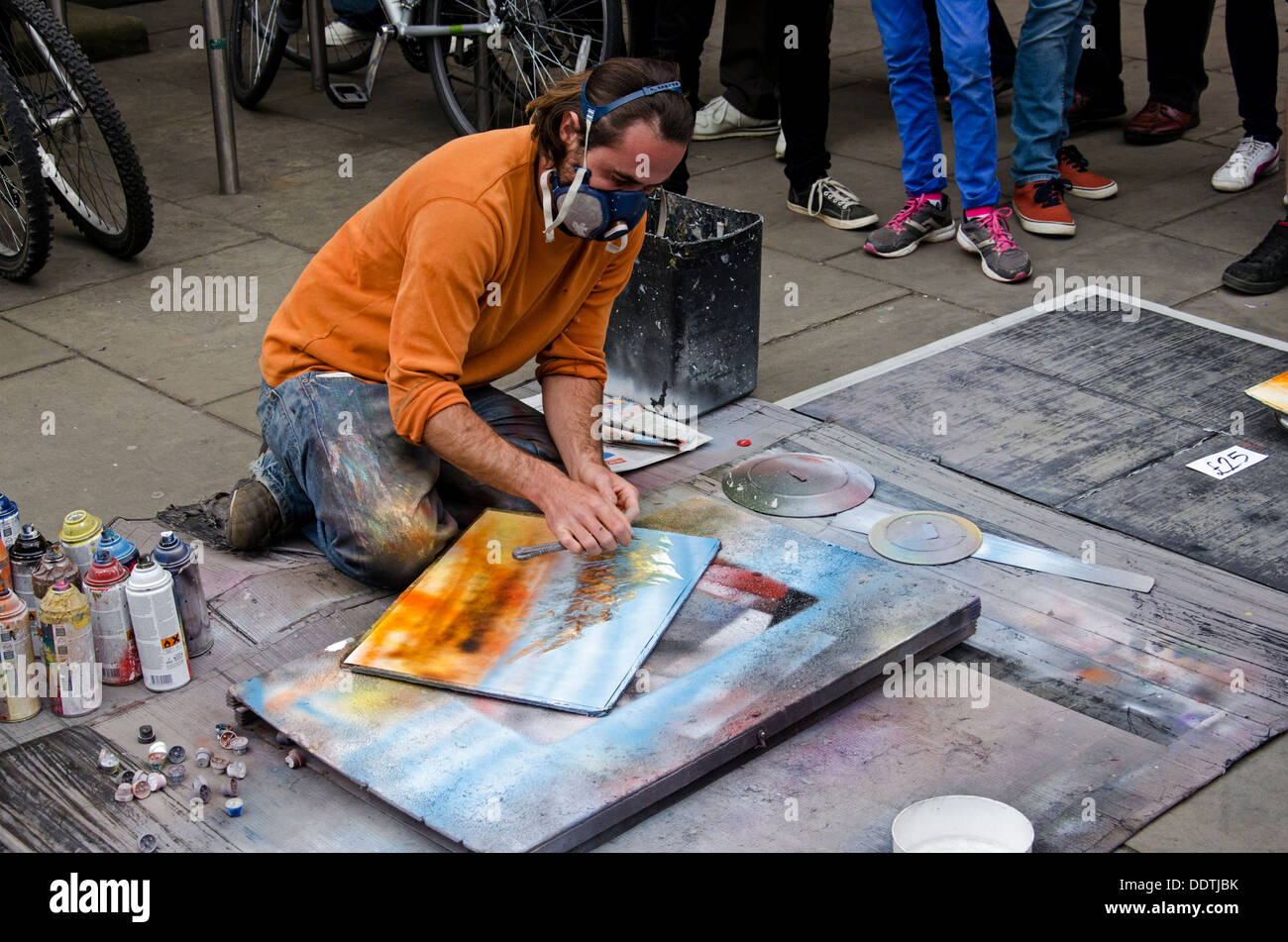 A Straßenkünstler Straßenmusiker und Verkauf seiner Arbeit auf dem Bürgersteig in der Princes Street, Edinburgh. Stockfoto