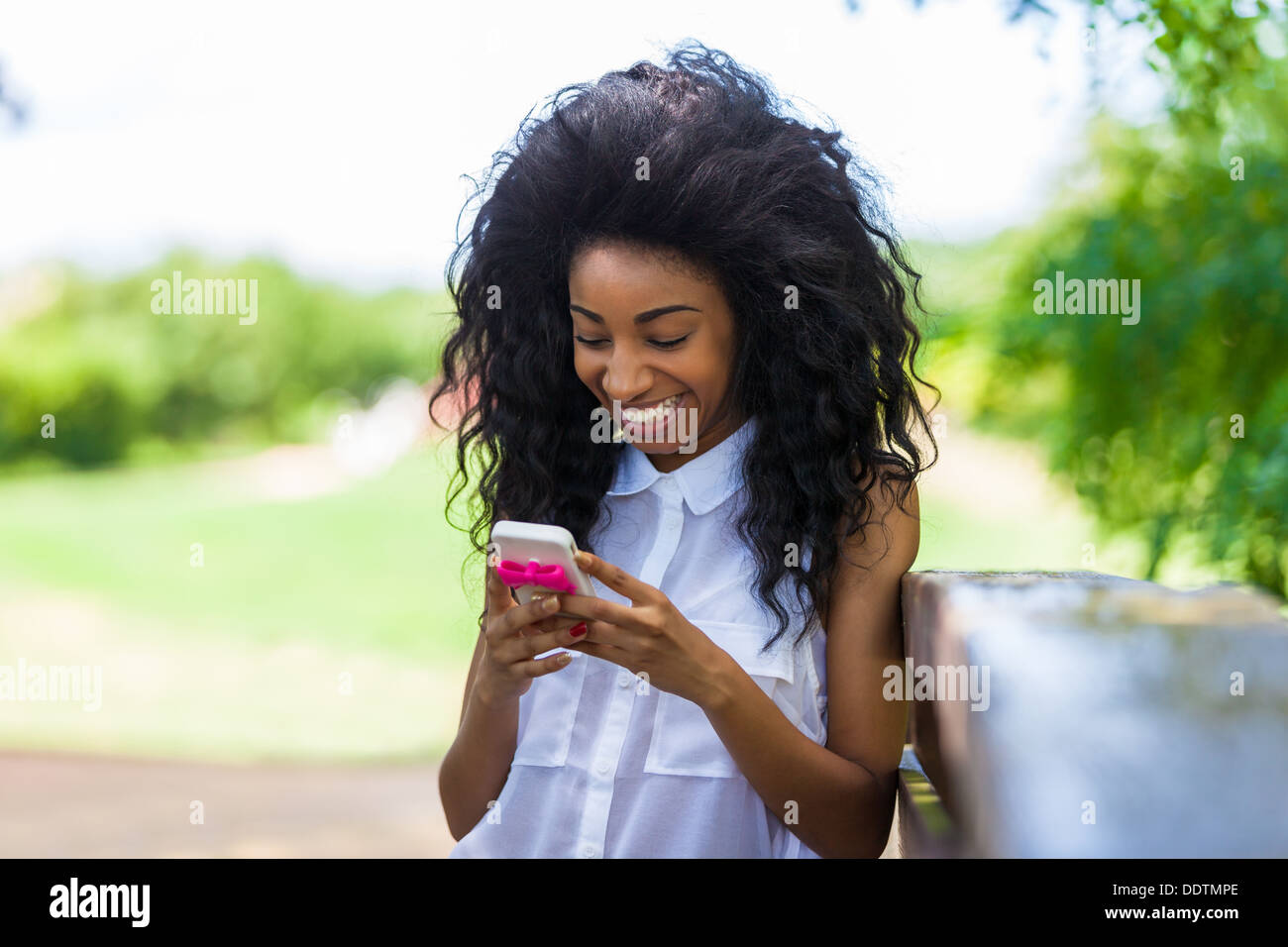 Outdoor-Porträt eines schwarzen Mädchens mit dem Handy telefonieren - afrikanische Bevölkerung Stockfoto