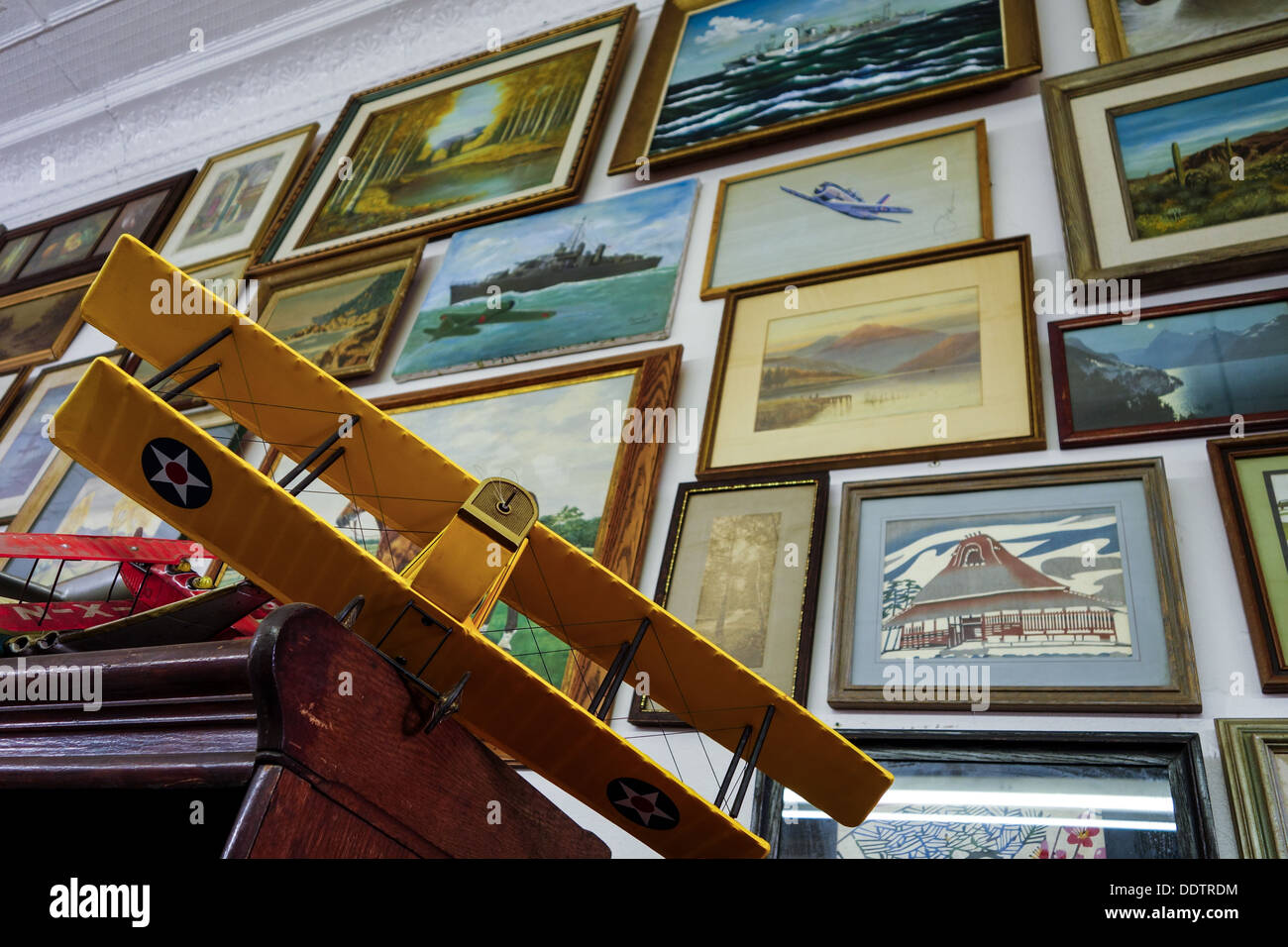 Vintage-Modell-Flugzeug vor dem Hintergrund der gerahmte Drucke und Gemälde in einem Antiquitätengeschäft Pittsburgh Stockfoto