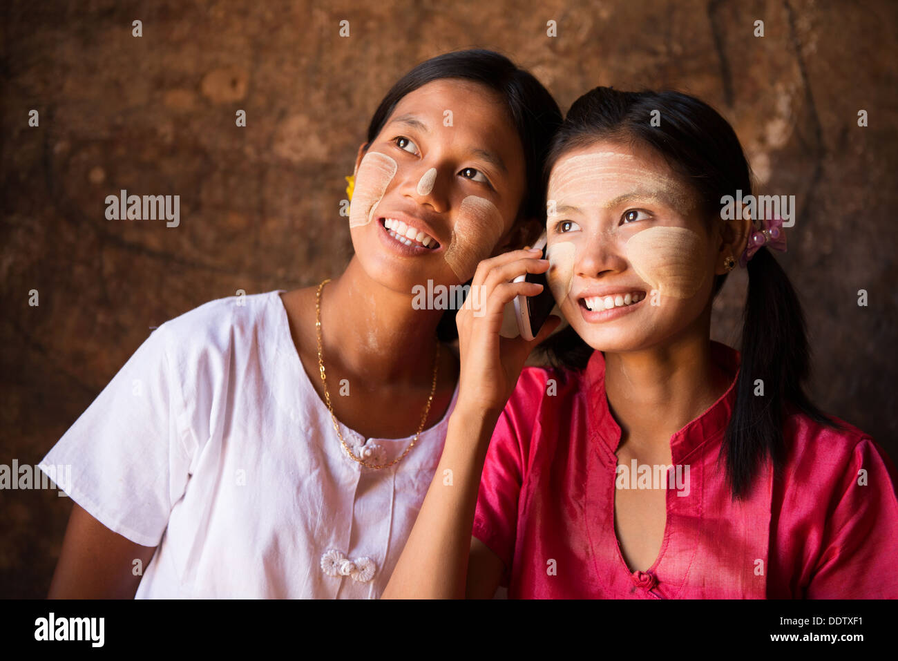 Porträt von zwei wunderschönen traditionellen Myanmar Mädchen mit Smartphone. Stockfoto