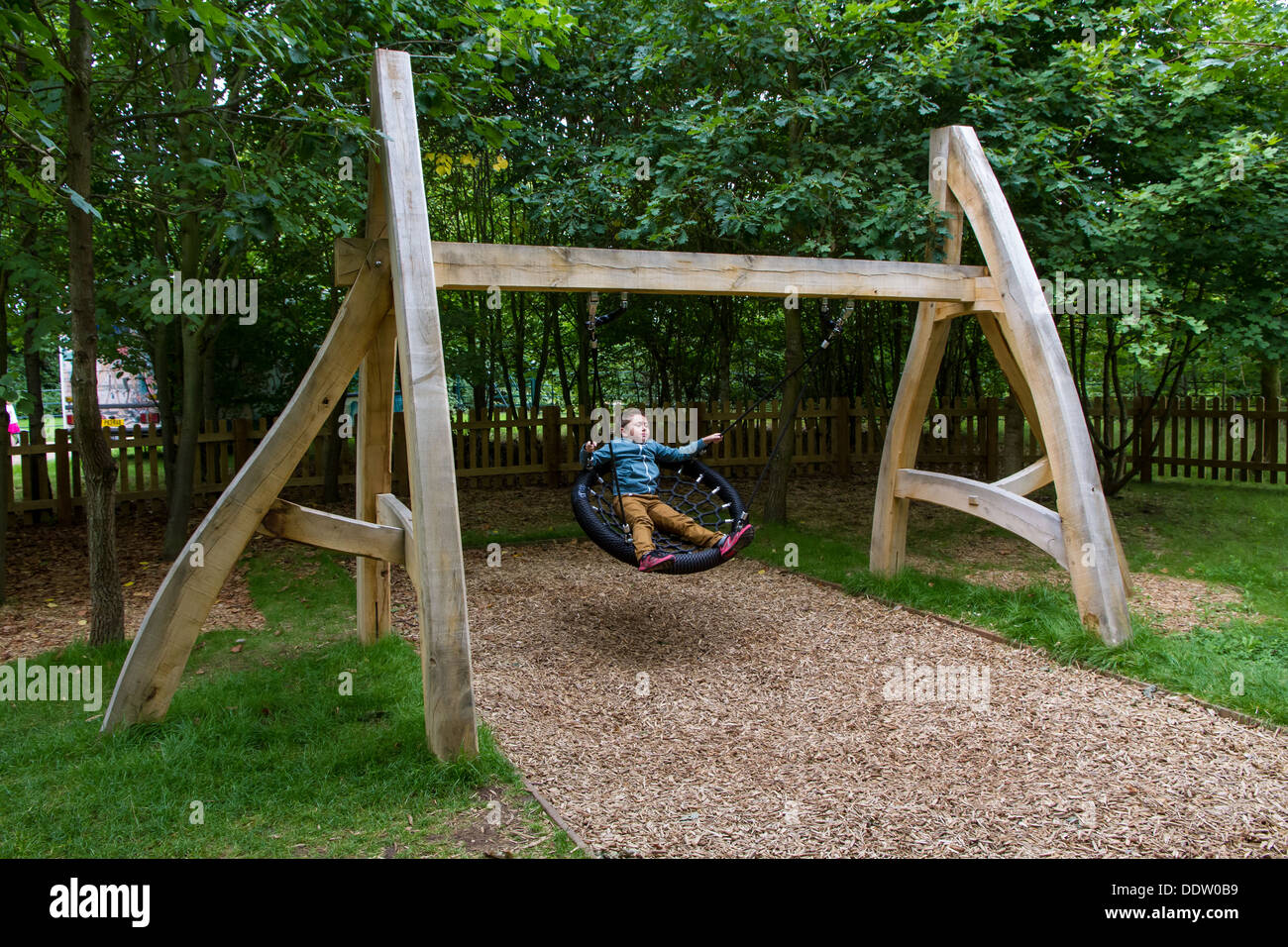 Kleiner Junge spielt auf das Spielen Wildnisgebiet Witley Gericht and Gardens in Worcestershire. Stockfoto
