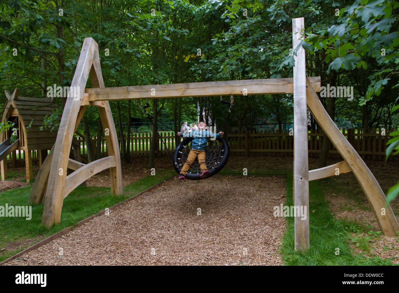 Kleiner Junge spielt auf das Spielen Wildnisgebiet Witley Gericht and Gardens in Worcestershire. Stockfoto