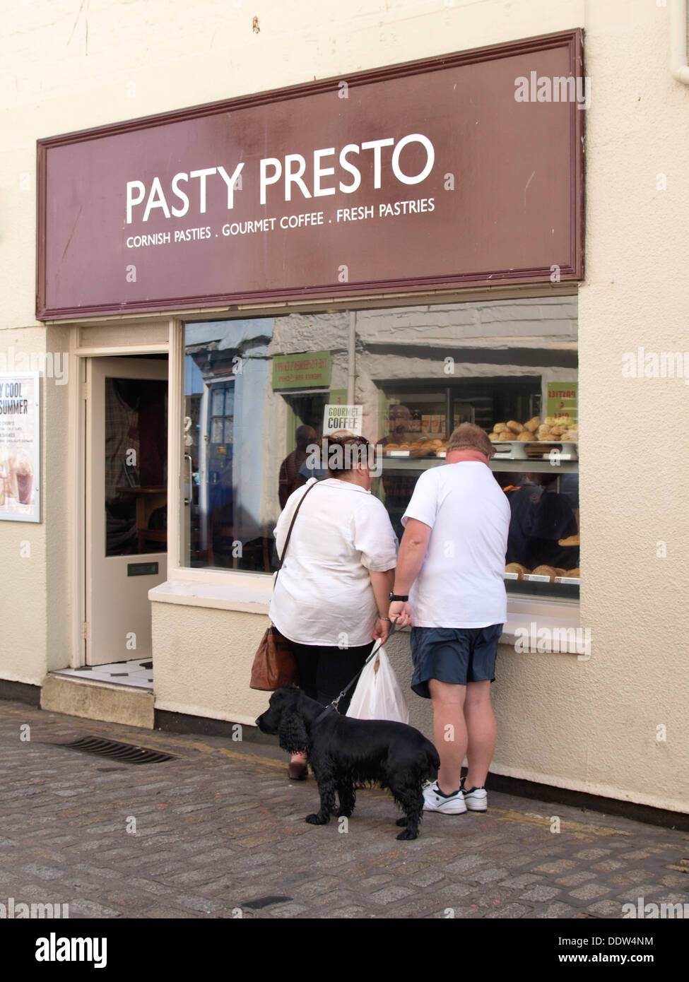 Übergewicht paar auf der Suche im Fenster eine pastöse Shop, Cornwall, UK 2013 Stockfoto