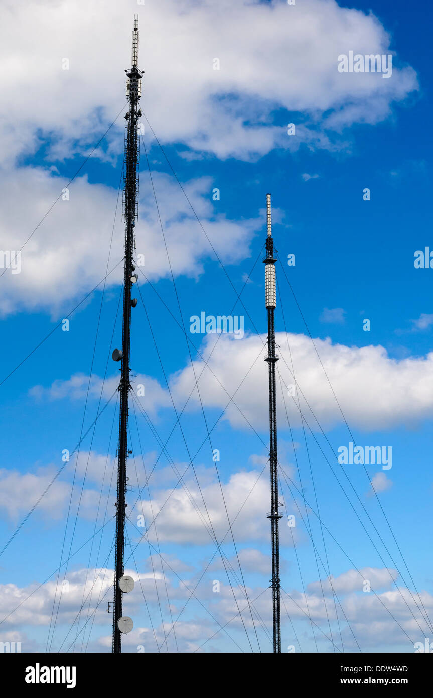 Zwei UK Fernsehen und Rundfunk Masten vor einem blauen Himmel mit Wolken. Stockfoto