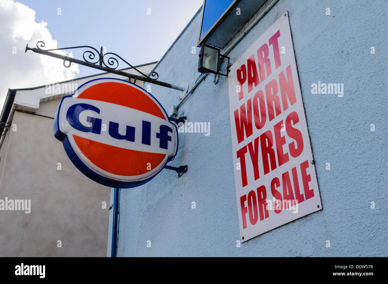 Schild an einer Garage Werbung Teil getragen Reifen zu verkaufen neben einer Golf-Schild. Stockfoto