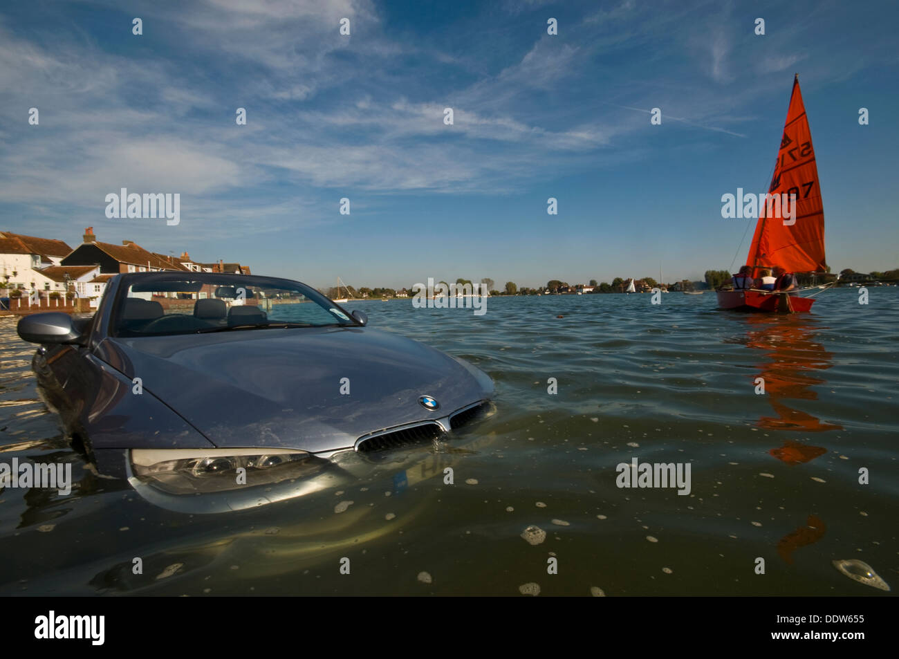 Ein Segelboot geht ein überschwemmten Auto im Meer Stockfoto