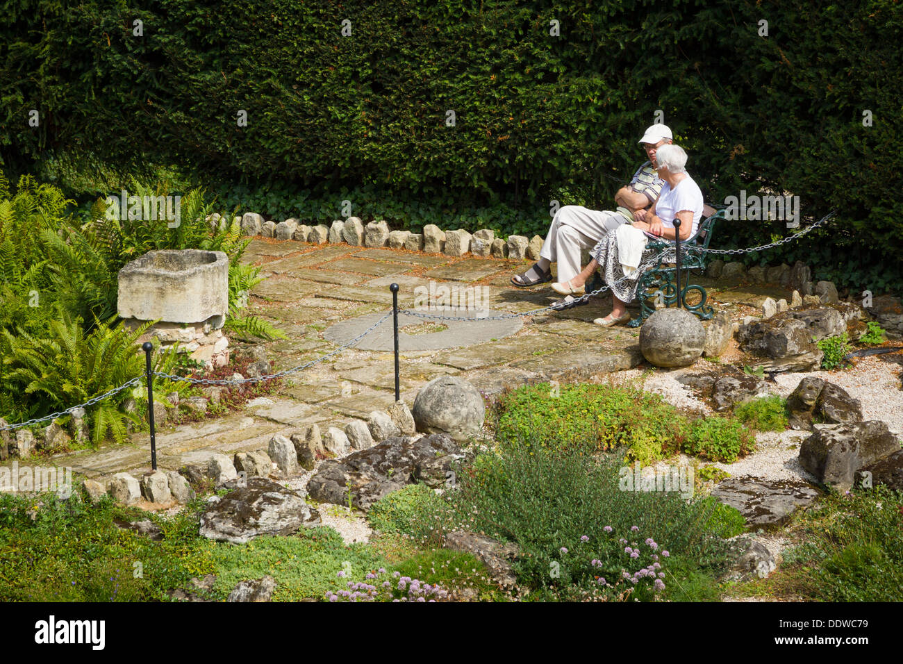 Älteres Ehepaar saß auf einer Bank im Brodsworth Hall Gardens, Doncaster, South Yorkshire entspannend. Stockfoto