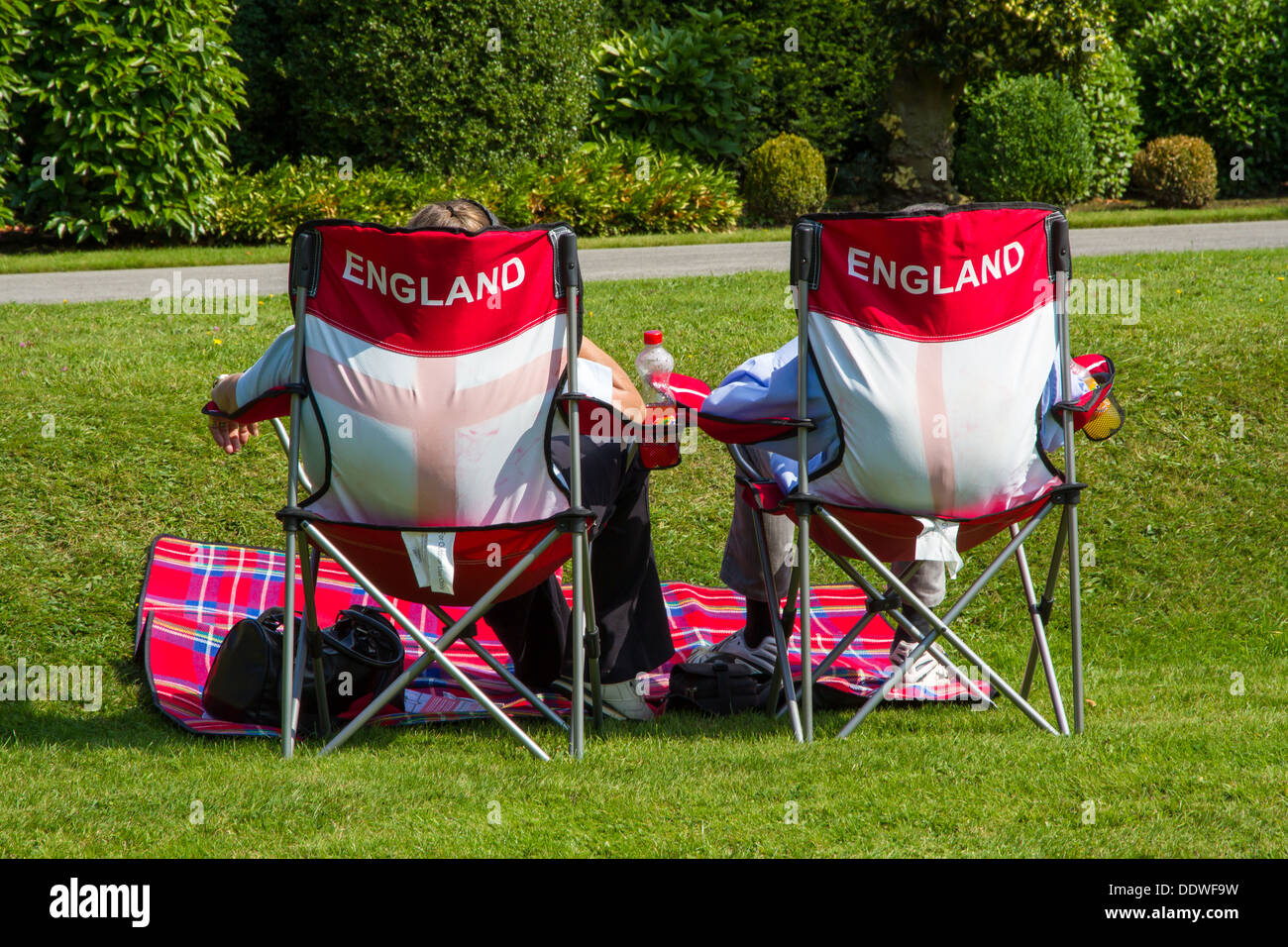 Ehepaar mit einem Picknick saß auf Klappstühlen mit England branding. Stockfoto