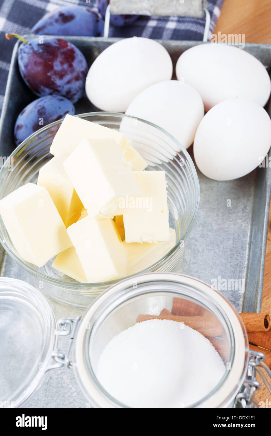 Butter in einer kleinen Glasschale zwischen Backzutaten auf einem Metalltablett Stockfoto